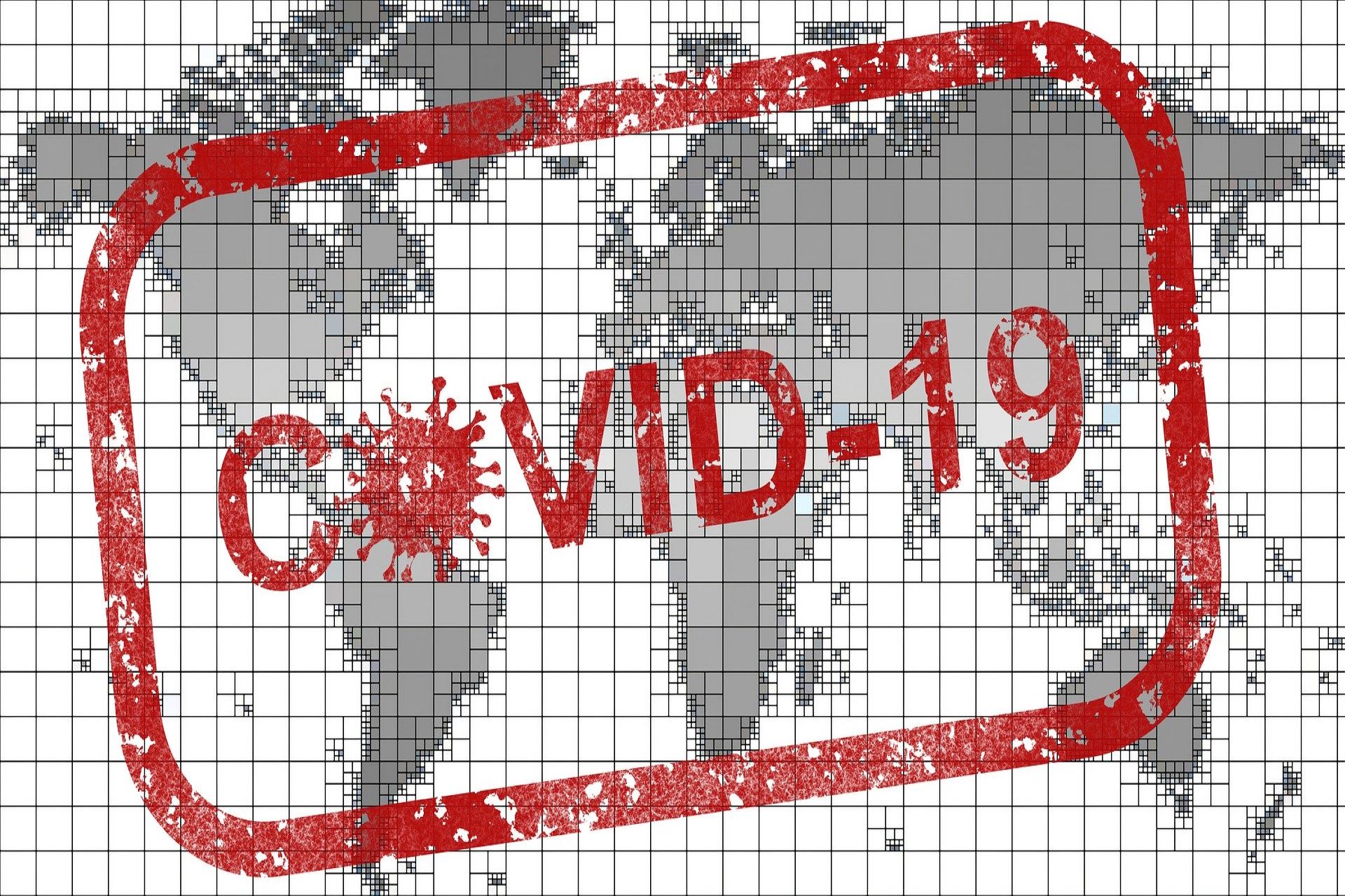 A stamp of the words COVID-19 over a world map